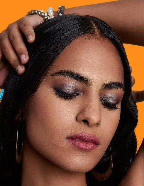 Model showcasing EYE LIGHT eyeshadow stick with stunning makeup look.