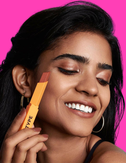 EYE LIGHT Eyeshadow Stick applied by a smiling model against a pink background.