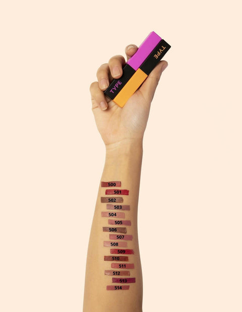 "Hand holding SOAK IT LIPSTICK with swatches on arm."