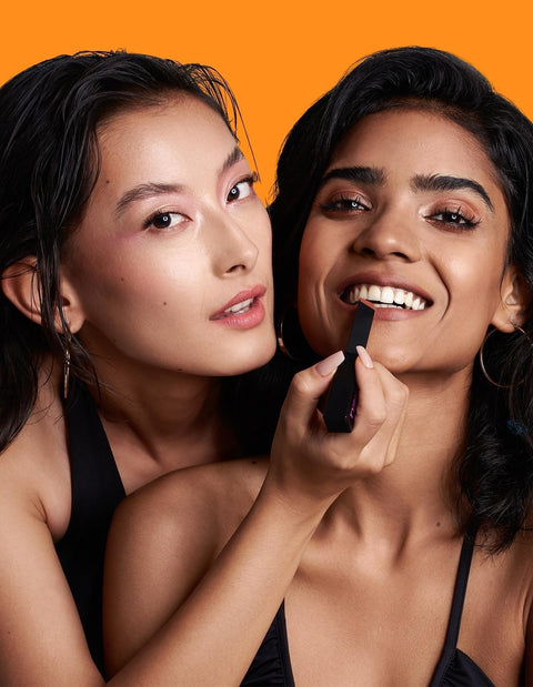 Diverse models applying lipstick from a vibrant lipstick combo collection.
