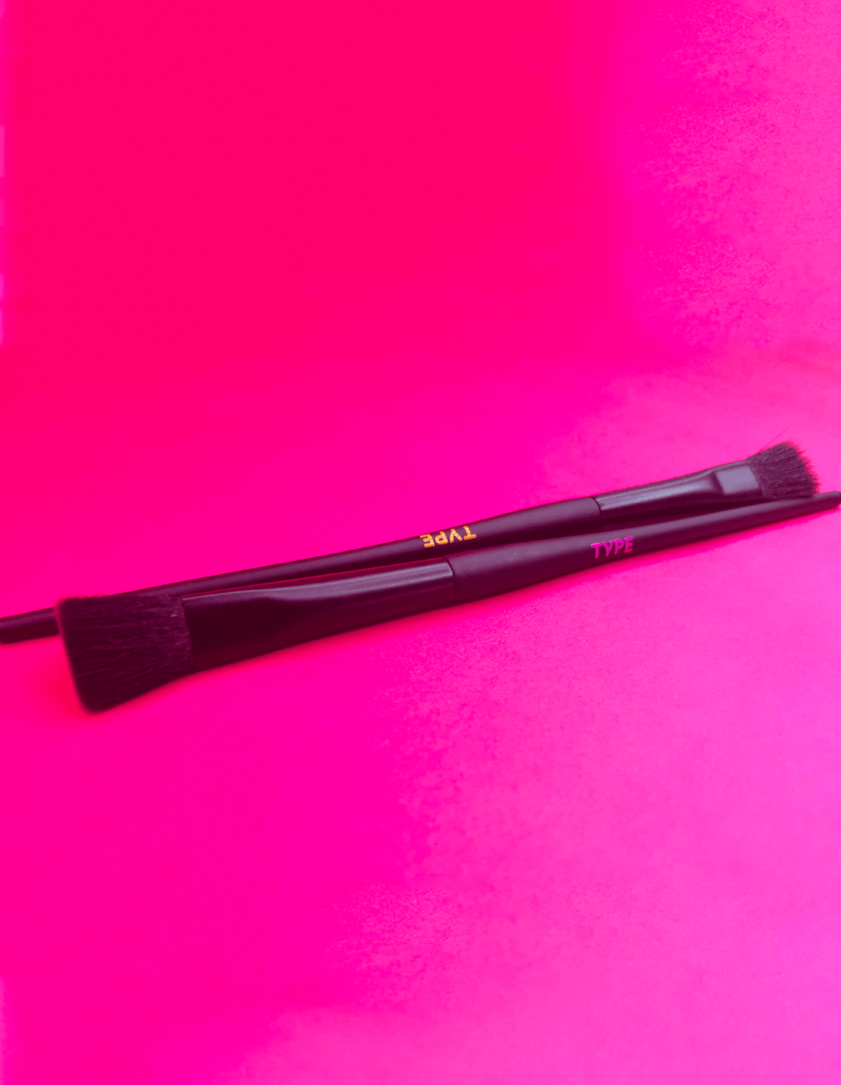 Makeup brushes on a vibrant pink background for "BRUSH UP ON SCIENCE."